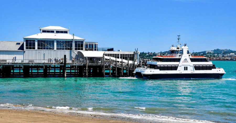 A Devonport ferry at the wharf on Auckland's harbour with turquoise water