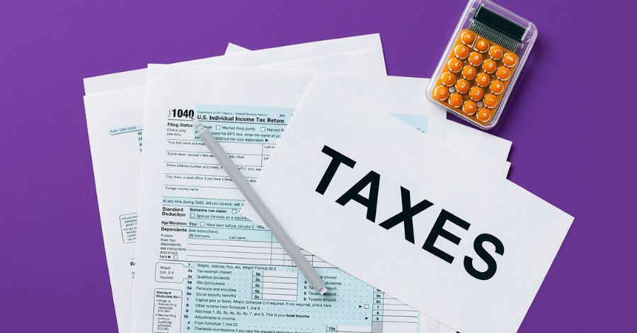 Tax return forms and a sheet reading TAXES beside an orange calculator on a purple background