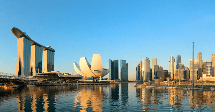 Singapore's Marina Bay skyline at golden hour, with Marina Bay Sands, the ArtScience Museum and the CBD reflected in the water