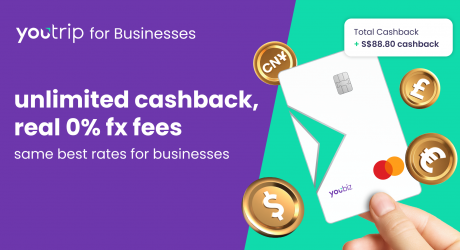 Hand holding a white YouBiz Mastercard beside gold currency coins and a cashback total