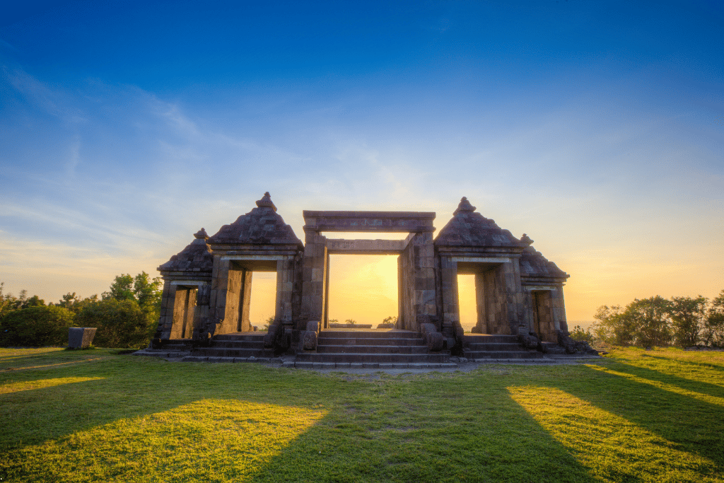 The stone gateways of Ratu Boko silhouetted against a golden sunset
