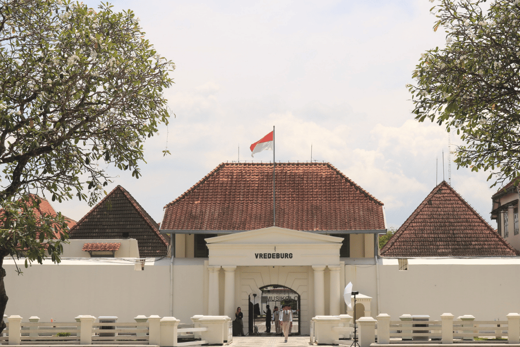 The whitewashed colonial gatehouse of Fort Vredeburg, flying the Indonesian flag