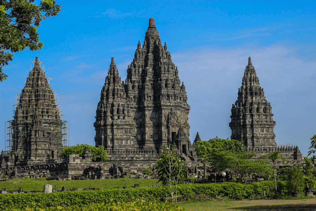 The tall, spiky stone towers of Prambanan Hindu temple against a blue sky