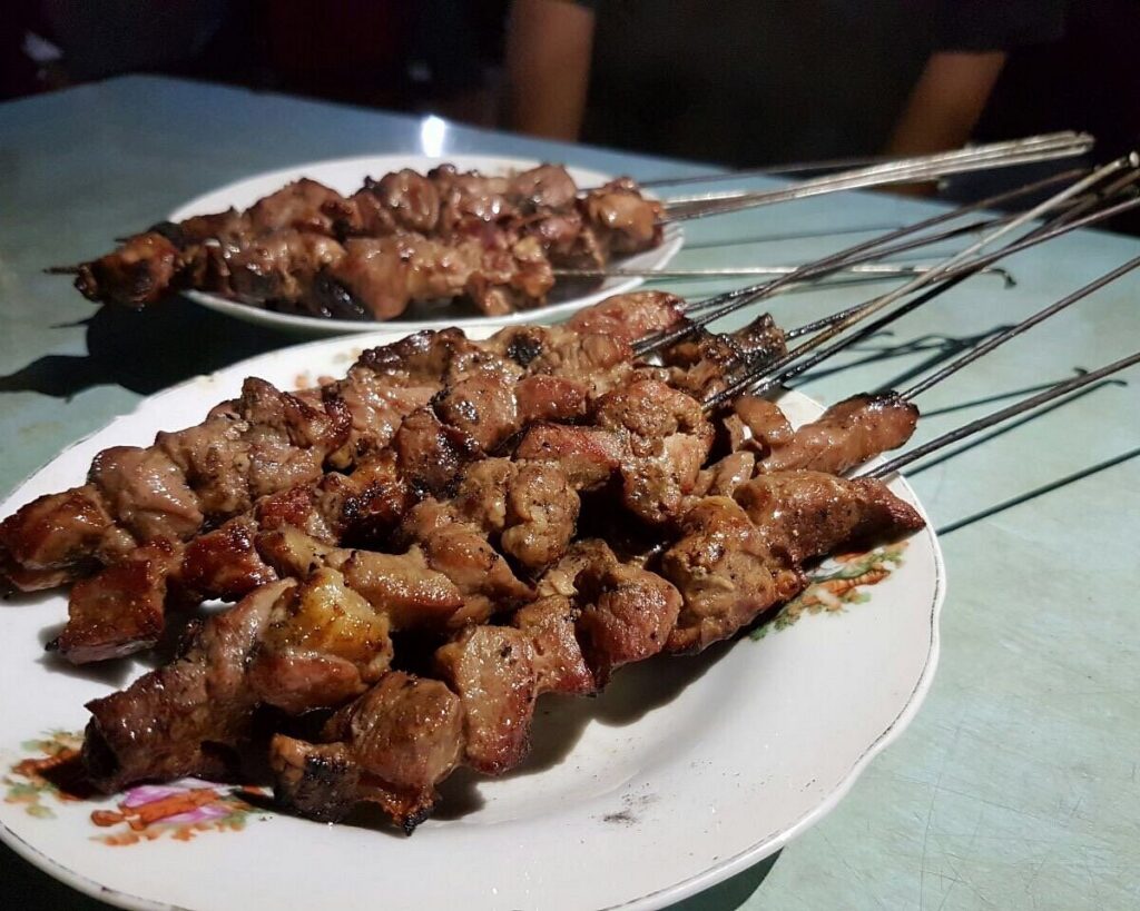 Plates of sate klathak, goat skewers grilled on metal bicycle-spoke skewers