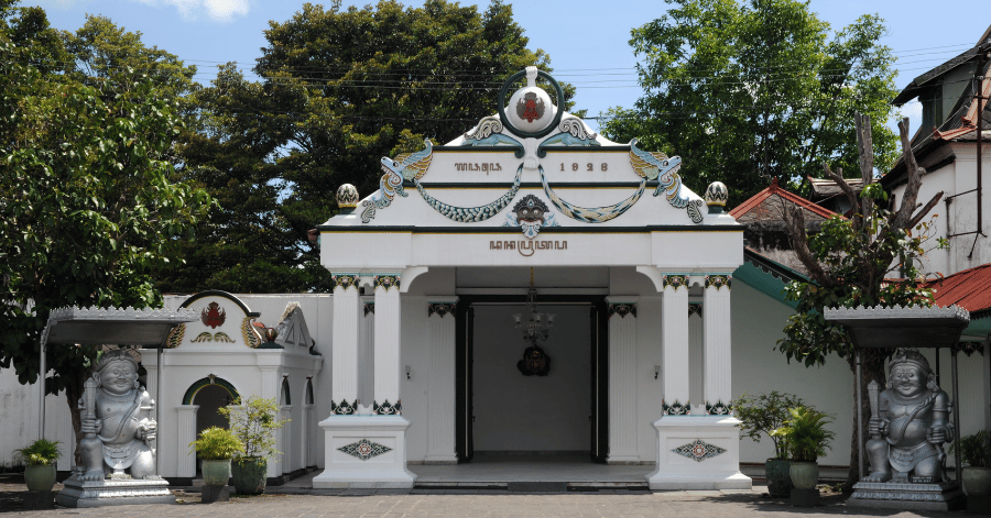 The ornate white entrance pavilion of Yogyakarta's Kraton, flanked by two guardian statues