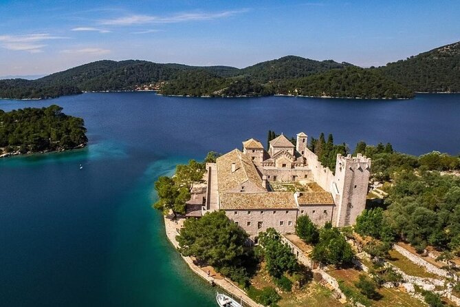 Aerial view of the stone Benedictine monastery on St Mary's Islet in a blue lake, Mljet