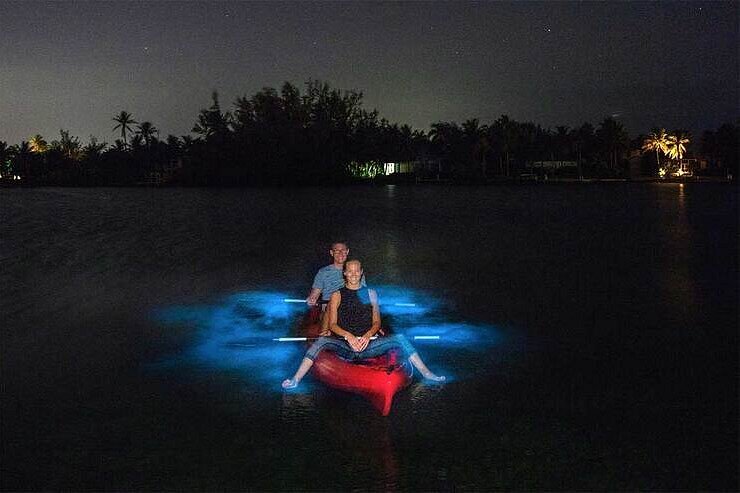 Two kayakers on a glowing bioluminescent bay at night, Mosquito Bay, Puerto Rico
