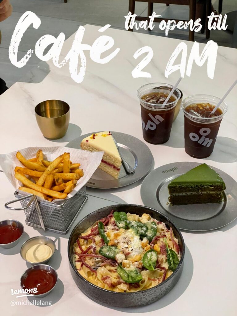 Table of pasta, truffle fries, cake slices and two iced Oomph coffees