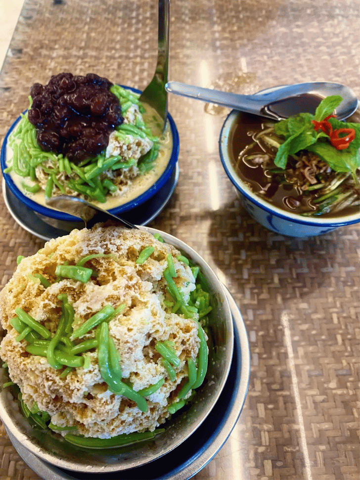 Bowls of cendol and ais kacang shaved-ice dessert topped with gula melaka