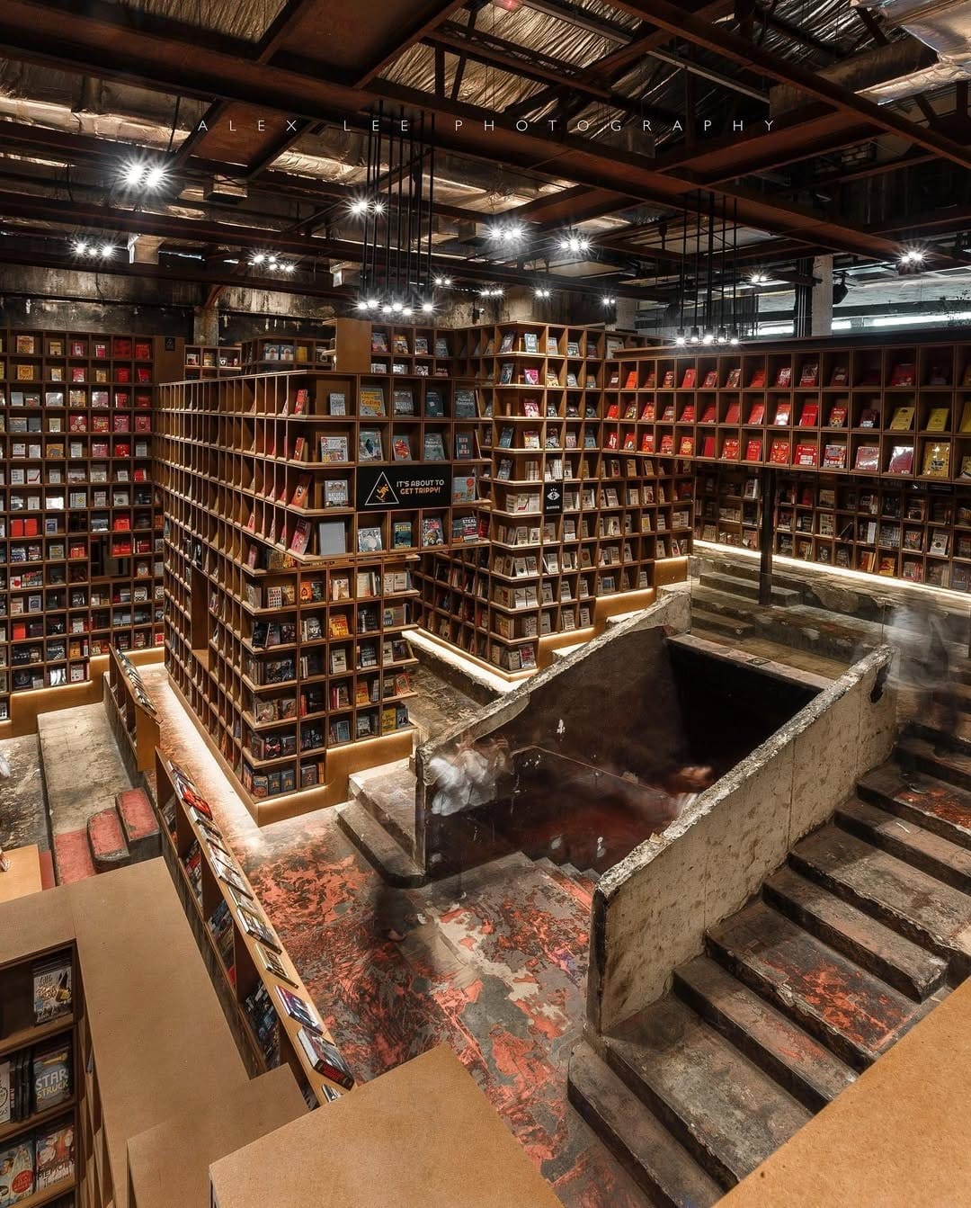 Towering wooden bookshelves across several levels at BookXcess inside REXKL