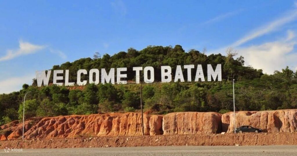 Giant white 'Welcome to Batam' letters on a green hillside