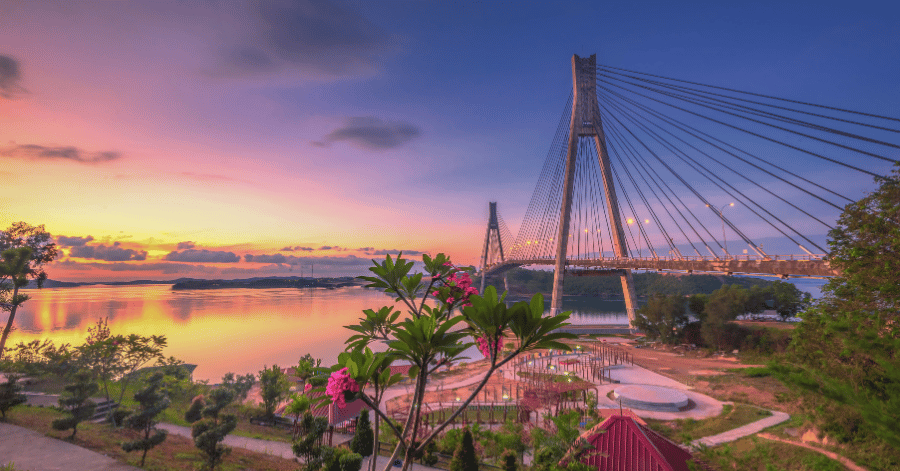 Barelang Bridge glowing at sunset over calm water, Batam