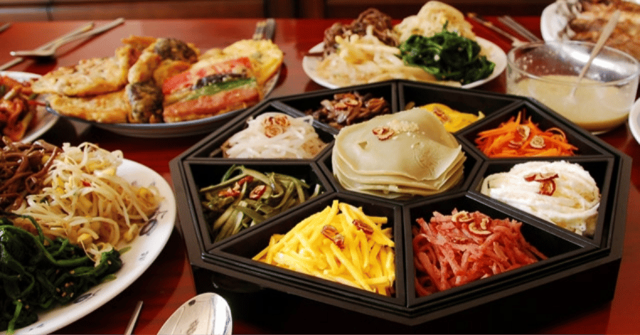 Spread of traditional Korean Chuseok dishes including a nine-sectioned gujeolpan platter and assorted banchan