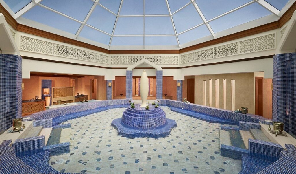 Blue-tiled hammam with a domed glass skylight and a central fountain at Anantara Desaru Coast