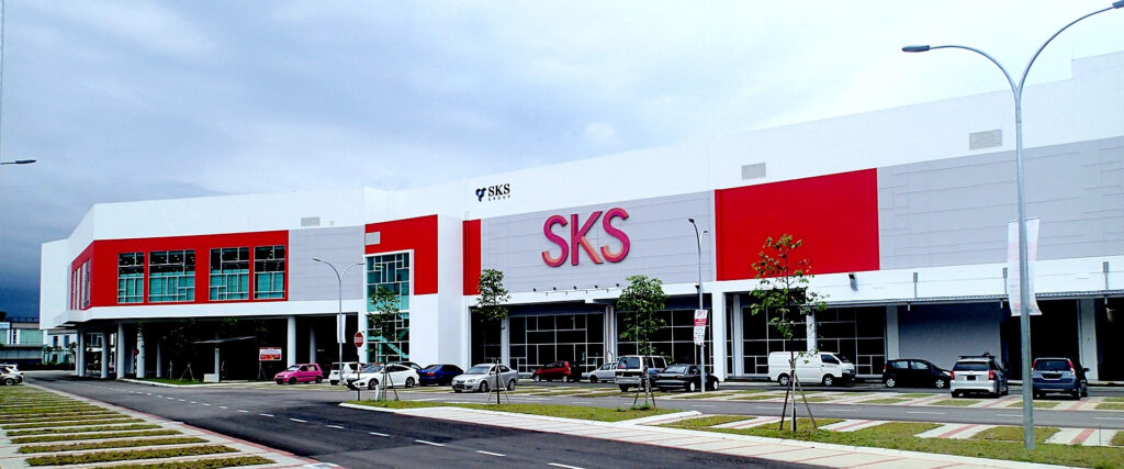 Red and white exterior of SKS City Mall in Bandar Penawar with cars parked outside