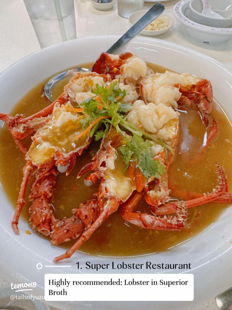 Lobster halves served in a golden superior broth on a white plate