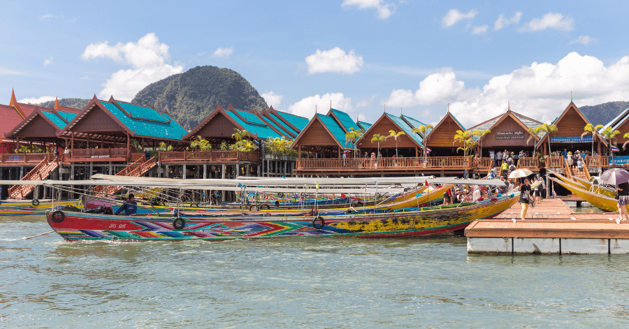 Colourful longtail boats moored at the stilt-built restaurants of Koh Panyi floating village