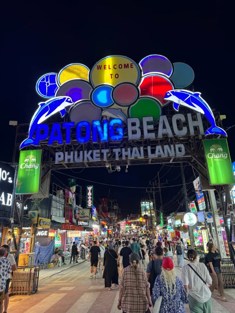 Crowds under the neon Welcome to Patong Beach archway on Bangla Road at night