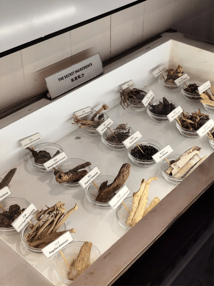 Labelled bowls of dried herbs and roots in a museum display of herbal tea ingredients