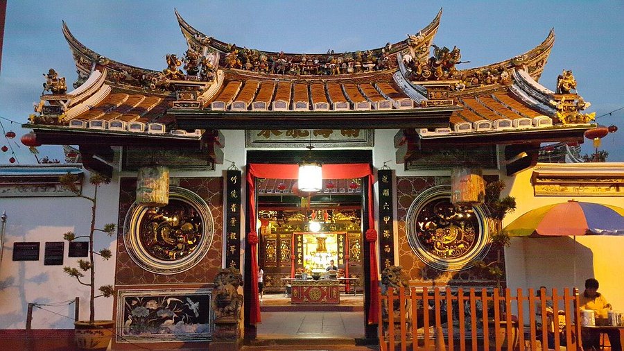 The ornate carved roof and entrance of Cheng Hoon Teng, Malaysia's oldest functioning Chinese temple, at dusk
