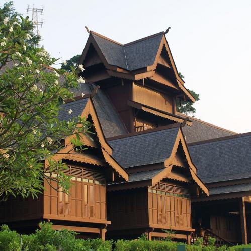 The tiered wooden roofs of the Malacca Sultanate Palace replica among trees