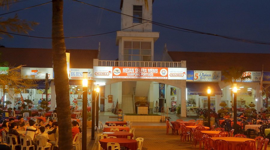 The Medan Selera food square at Malacca's Portuguese Settlement with outdoor tables lit at night