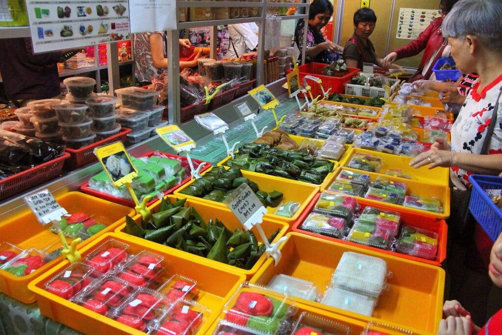 Colourful trays of handmade nyonya kuih wrapped and boxed at a Malacca kuih shop