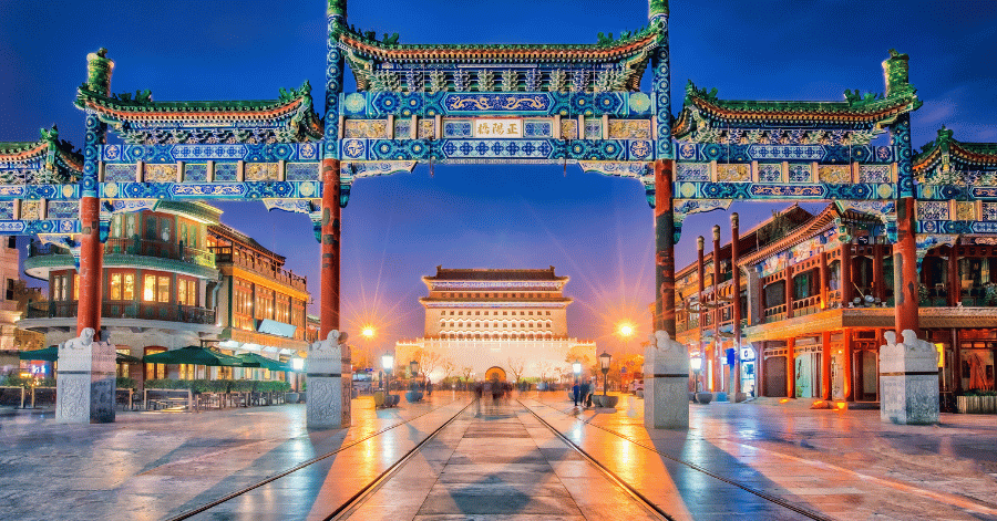 Traditional Chinese paifang archway on Beijing's Qianmen Street lit up at dusk
