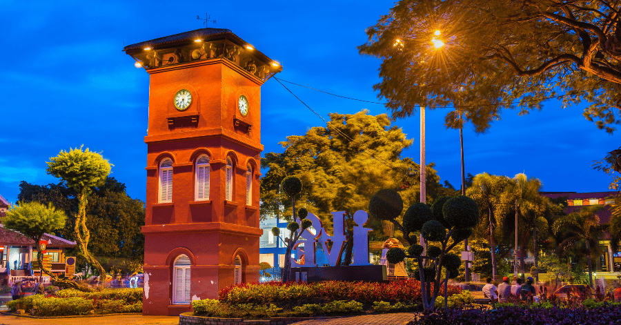 The red clock tower lit at dusk in Malacca's Dutch Square