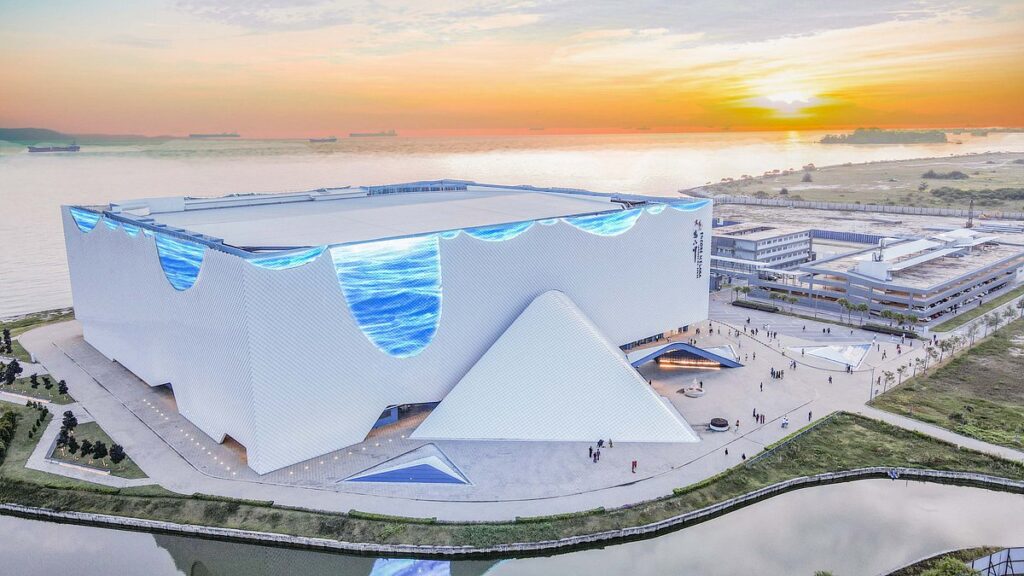 The wave-shaped Encore Melaka theatre building beside the Malacca Strait at sunset