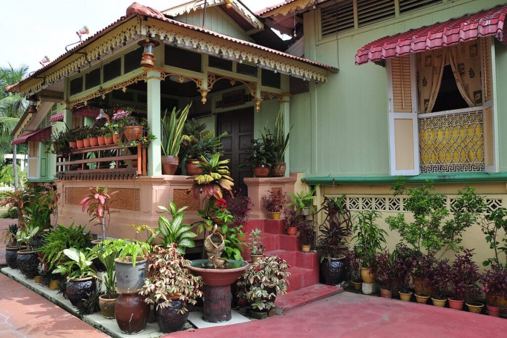 The traditional Malay house of Villa Sentosa with potted plants in the riverside village of Kampung Morten