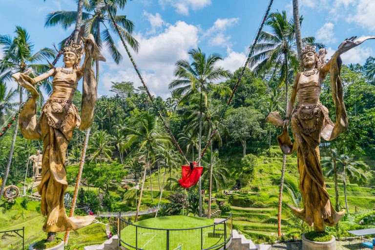 Carved figures and a swing over jungle rice terraces at Alas Harum, Bali