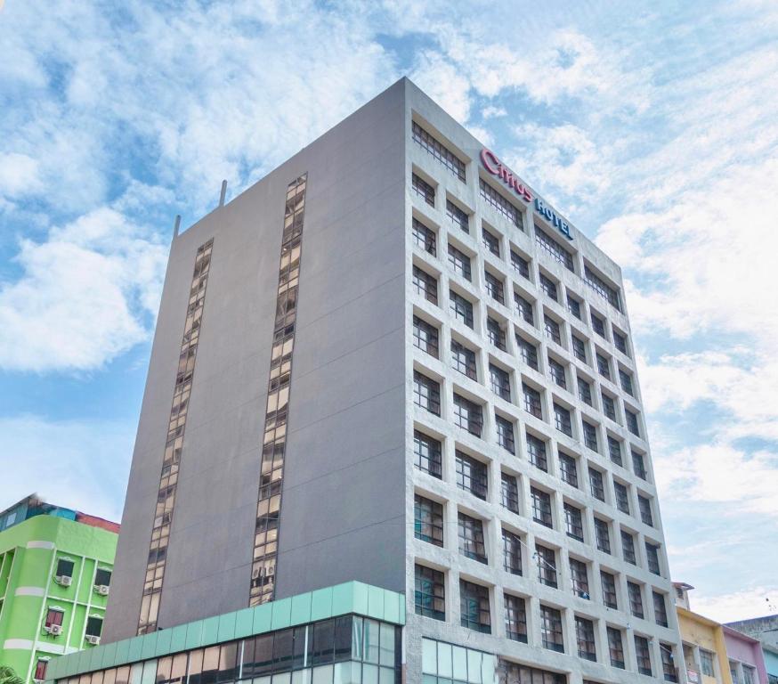 Citrus Hotel's tall grey tower with rooftop signage against a blue sky in Johor Bahru