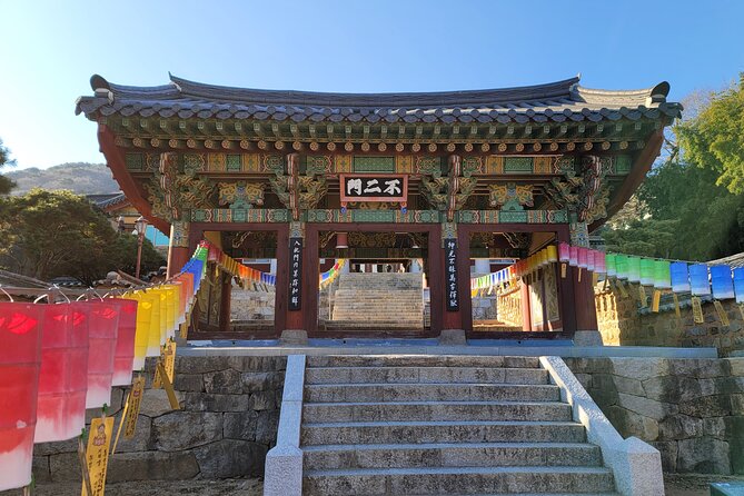 Traditional temple gate with hanging lotus lanterns and stone steps at Beomeosa