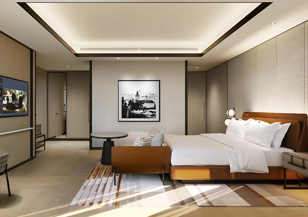 Sheraton Johor Bahru room with a large bed, leather bench and a framed cityscape print