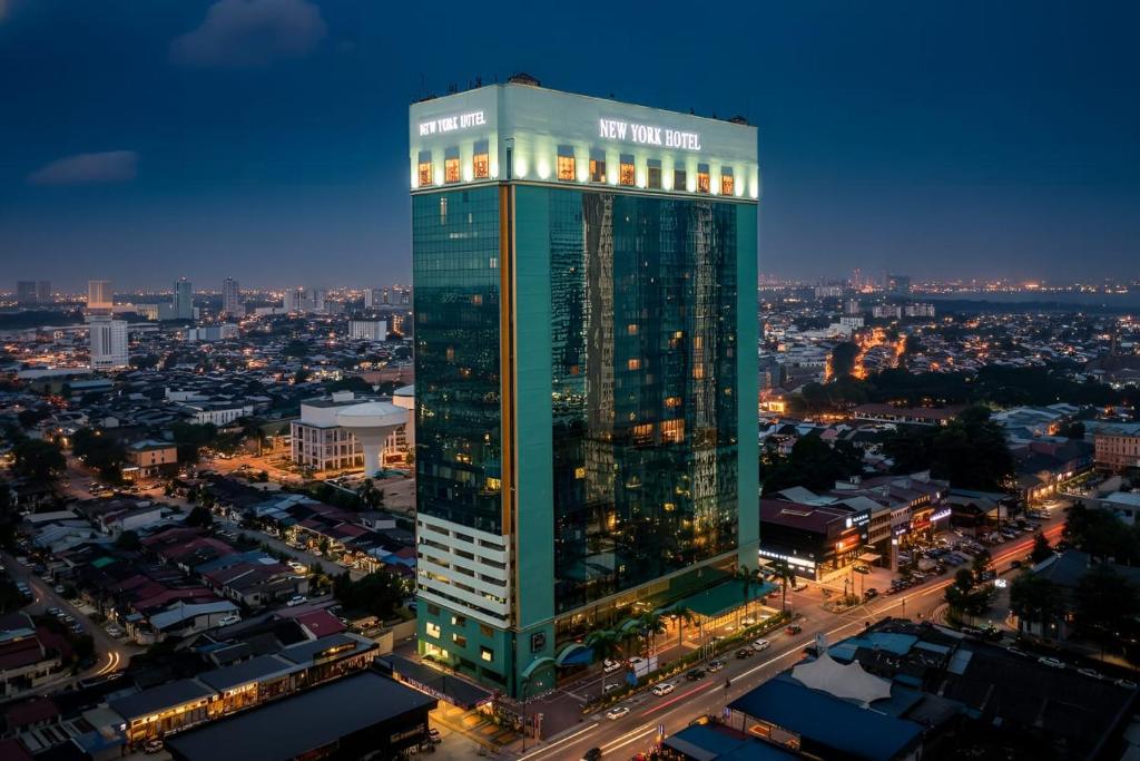 New York Hotel's illuminated glass tower rising over the Johor Bahru skyline at night