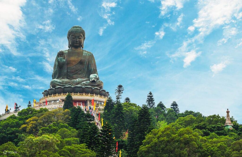 The bronze Tian Tan Big Buddha seated atop its hilltop platform above forested slopes on Lantau Island