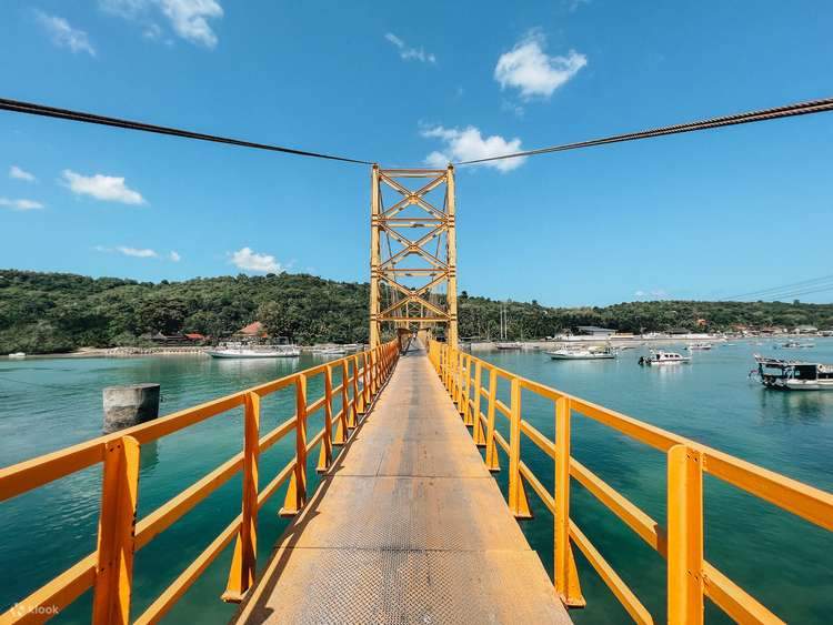 The yellow suspension bridge linking Nusa Lembongan and Nusa Ceningan over clear water