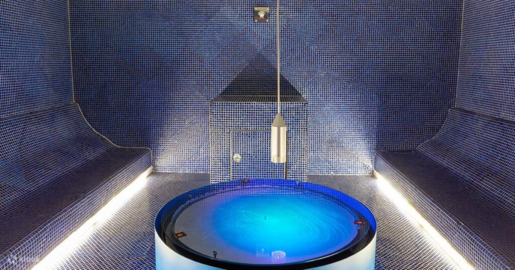 Blue-lit themed bathing room with a circular pool at Spa Land Centum City
