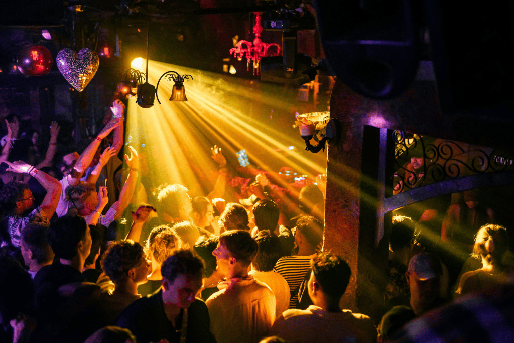 Crowd dancing under stage lights at a busy Seminyak nightclub