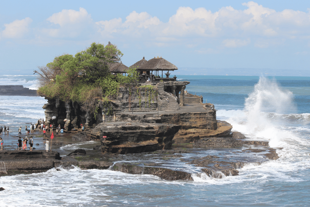 Tanah Lot temple on a rocky outcrop with waves breaking around it, Bali