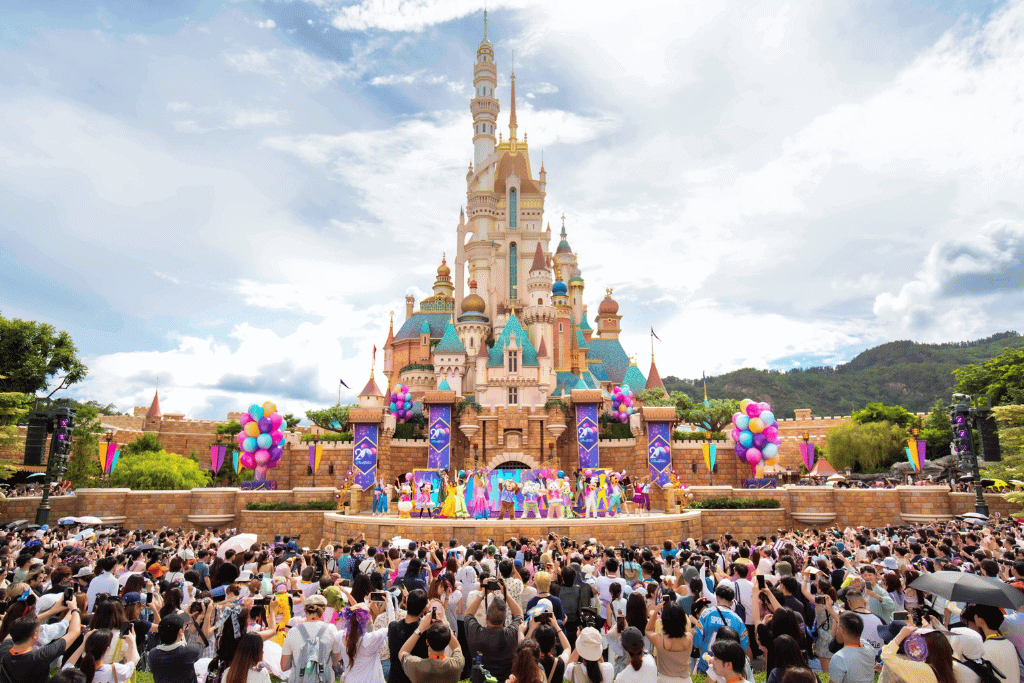 Crowds watching a live stage show in front of the castle at Hong Kong Disneyland