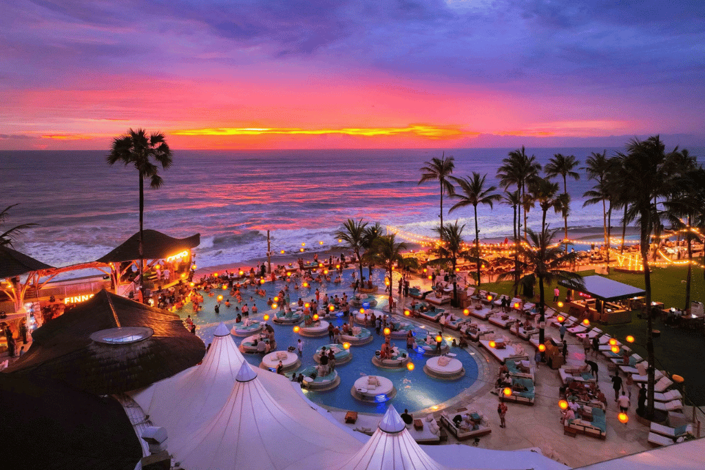 Beach club infinity pool and loungers overlooking the sea at sunset, Canggu