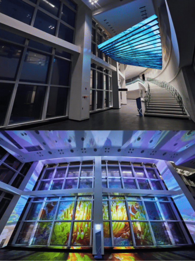 Illuminated media-art glass wall and staircase inside Busan X the Sky at night