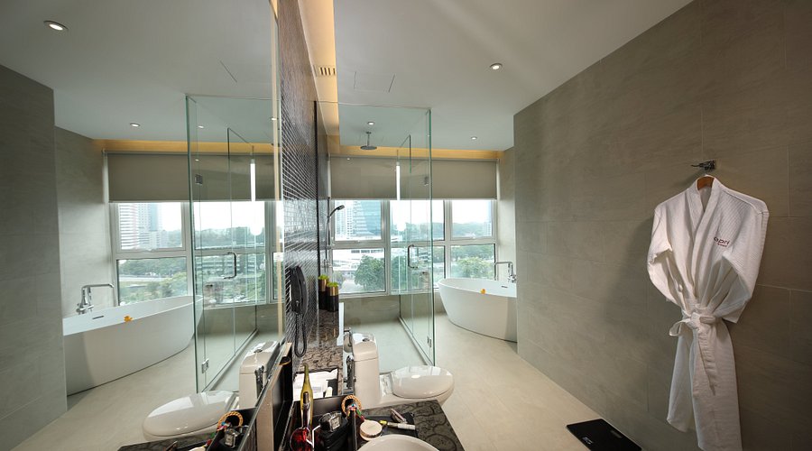 Spacious Capri by Fraser bathroom with a freestanding tub, glass shower and a city view