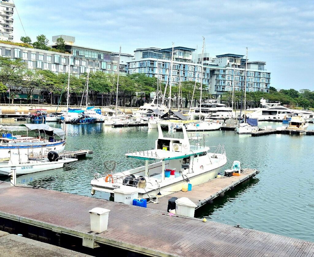 Yachts and boats moored at Puteri Harbour marina with waterfront residences behind