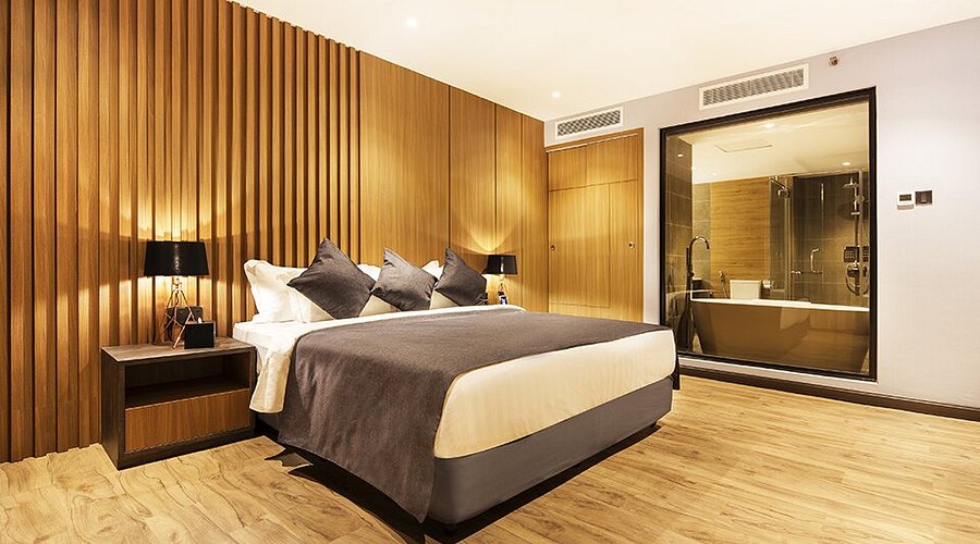 Trove Hotel room with a timber-slat feature wall and a glass-walled bathroom with a tub