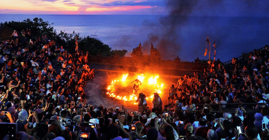Kecak fire dance performed before a large crowd at dusk in Bali