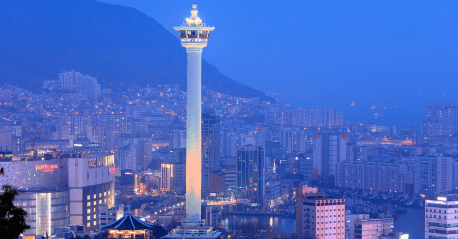 Busan Tower lit at dusk above the city in Yongdusan Park