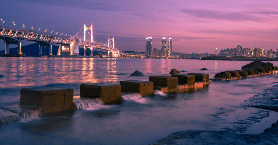 Gwangan Bridge and city lights at dusk seen across Gwangalli Beach